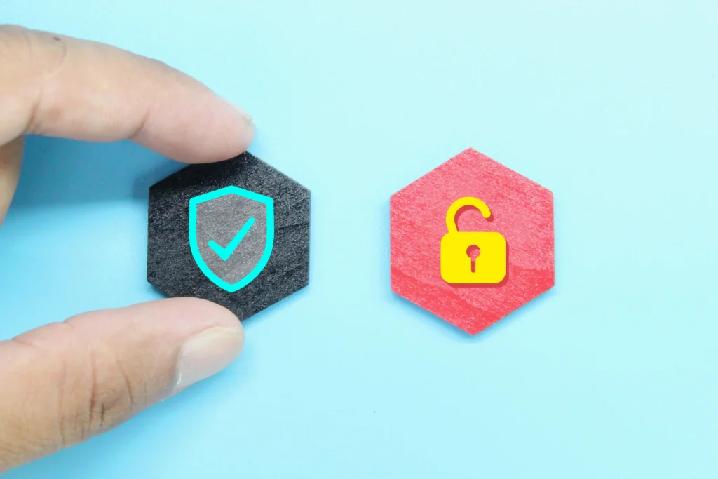 Conceptual cybersecurity image showing a hand selecting a secure shield tile next to an open lock tile.