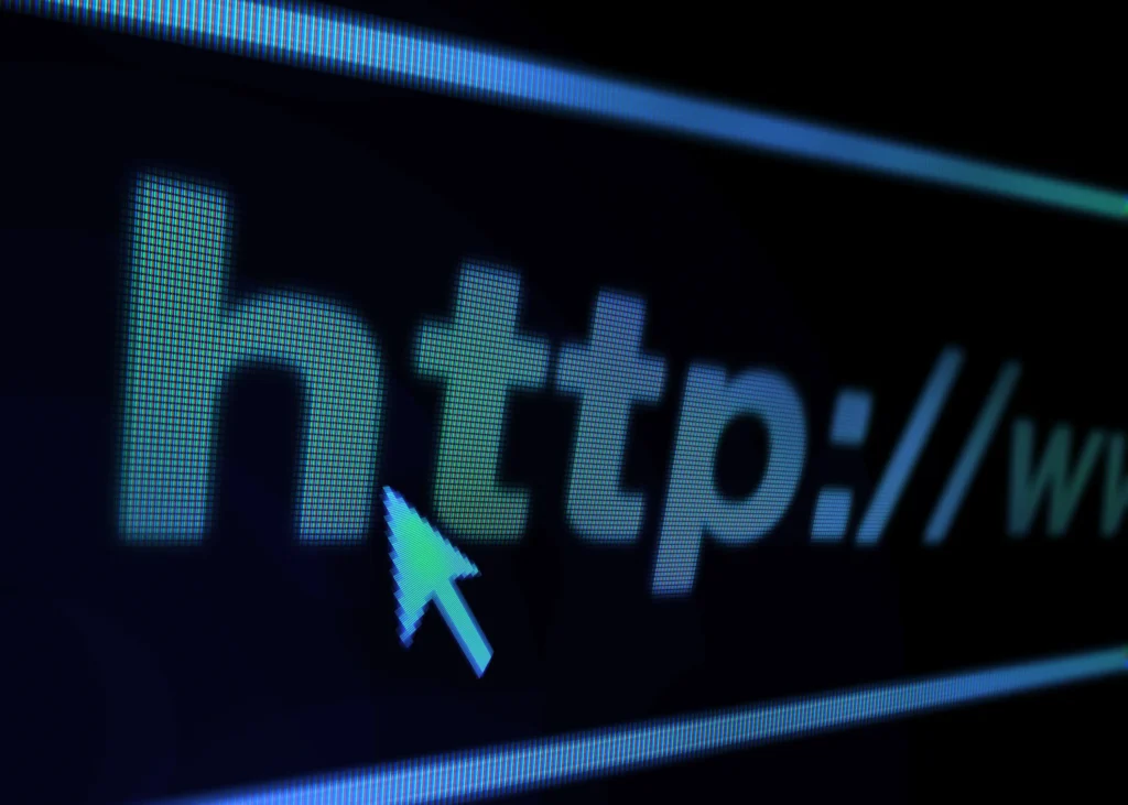 Extreme macro close-up of a digital screen showing a web address bar starting with http:// and a mouse cursor.